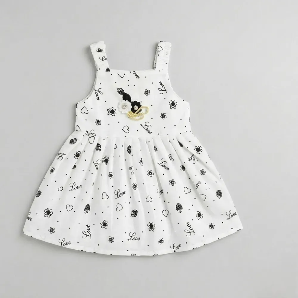 White Sleeveless Dress with Black Pattern and Floral Brooch